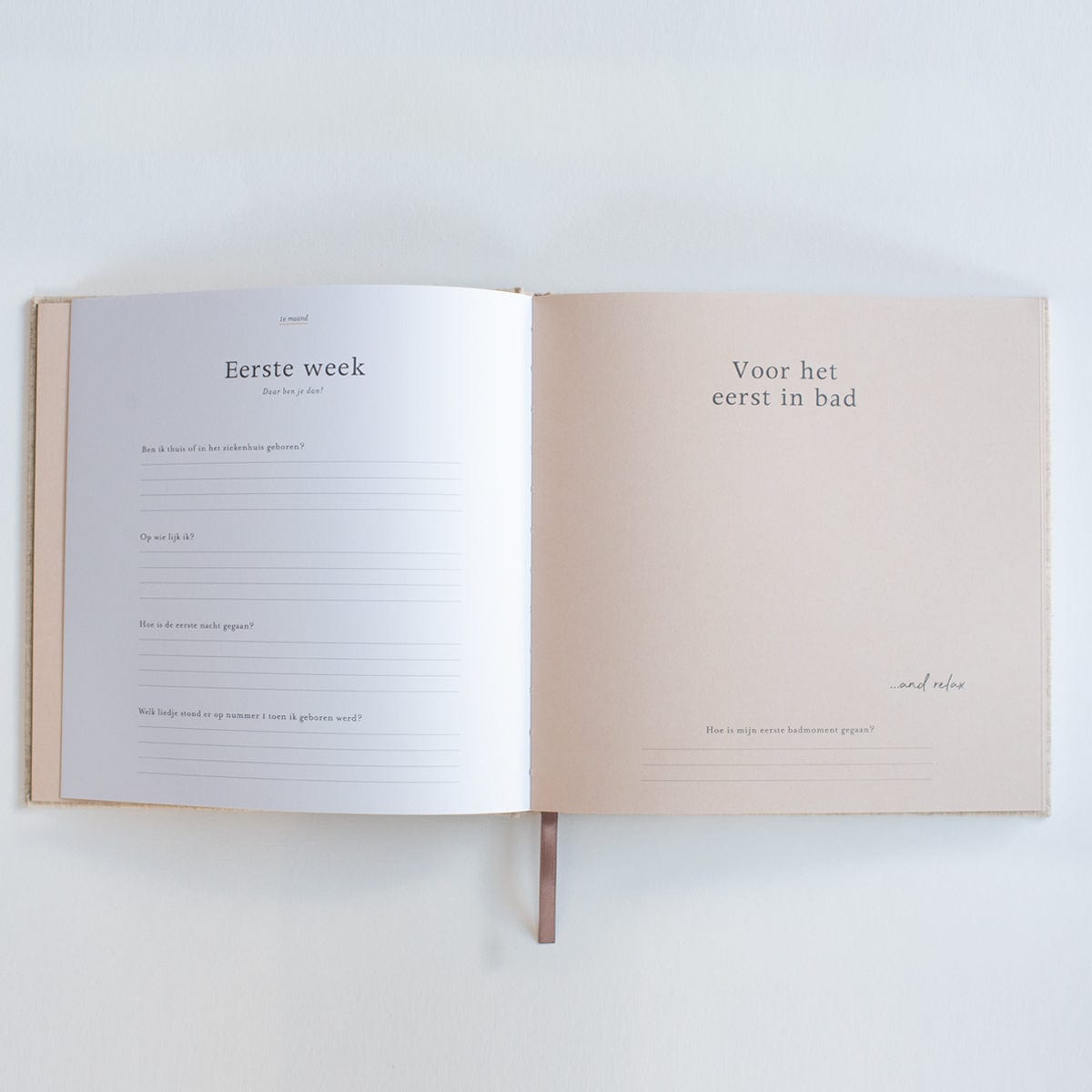 Invulboek Mijn Eerste Jaar open op de pagina’s ‘Eerste week’ en ‘Voor het eerst in bad’, met zachtroze rechterpagina.