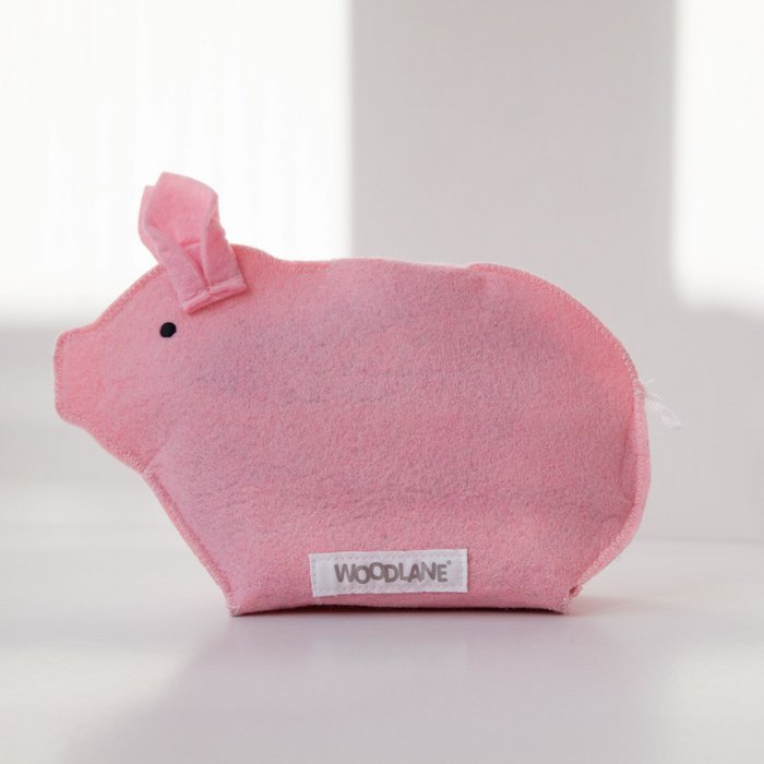 Roze Piggy-spaarvarken van vilt zonder verpakking, met zwart oogje en wit label op een lichte tafel
