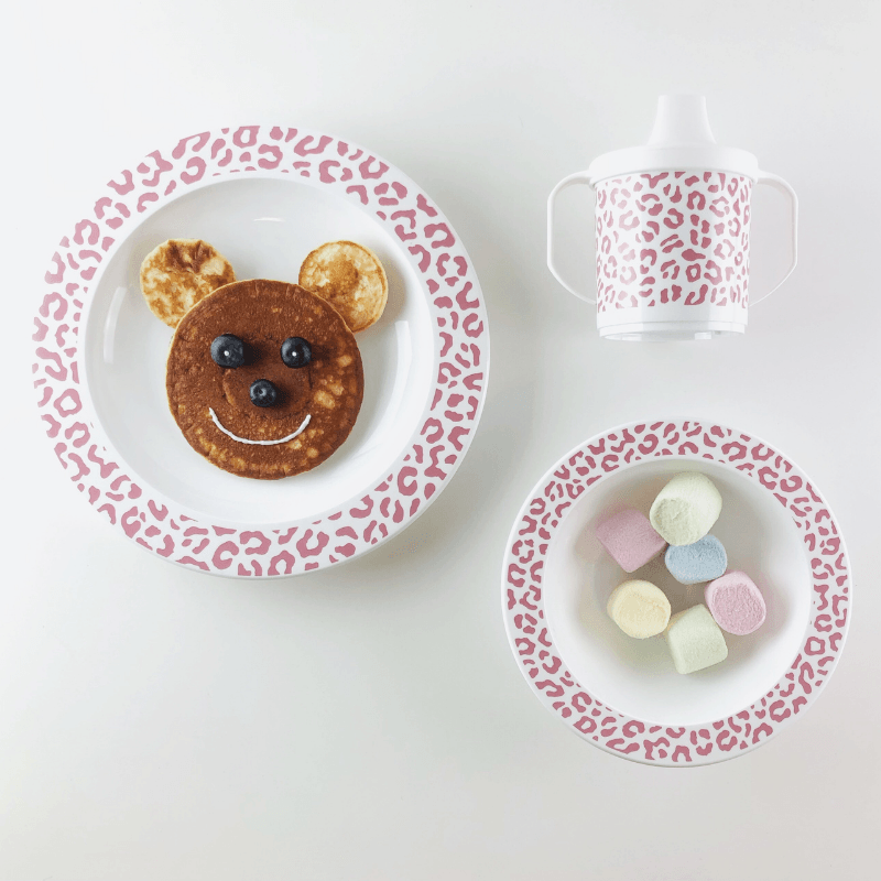 Servies Leopard Blush met een pannenkoekengezicht op het bord, marshmallows in de kom en een tuitbeker ernaast.