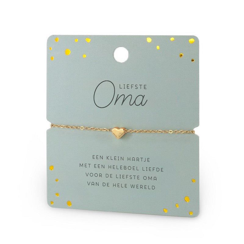 Goudkleurige armband met hartje op een lichtgroene kaart met de tekst ‘Liefste Oma’ en gouden stippen.