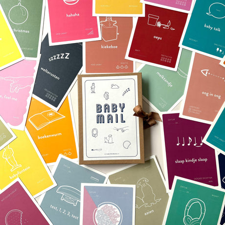 Baby Mail bewaardoosje met bruin sluitlint, omringd door kleurrijke mijlpaalkaarten.