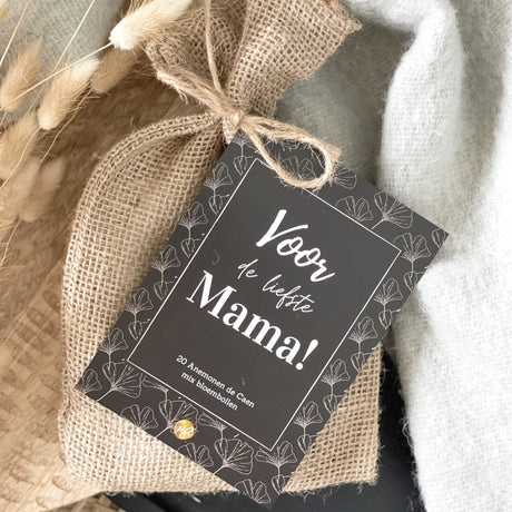 Bruin zakje bloembollen met kaartje ‘Voor de liefste mama’, naast droogbloemen en een witte doek