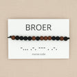 Morsecode-armband voor broer met zwarte en bruine kralen op een wit kaartje met ‘broer’ en de bijbehorende morsecode.