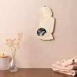 Houten fotolijst Echo in de vorm van een zwangere vrouw, met echofoto, aan een roze muur boven een kast.