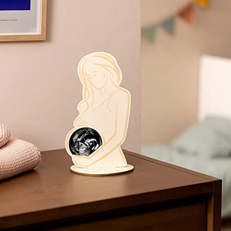 Houten fotolijst Echo met echofoto in de buik van een zwangere vrouw, op een voetje op een houten kast.