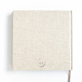 Achterkant van het lichtbeige invulboek Mijn Zwangerschap met klein logo onderaan en bruin leeslint