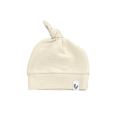 Beige knoopmutsje in ribstof met brede omslag en een wit label met veertjes.