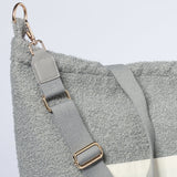 Detail van de grijze Mom Bag Teddy Bouclé met verstelbare schouderriem en goudkleurige karabijnhaak.