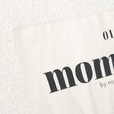 Detail van het etiket met zwarte opdruk op de ivoorkleurige Mom Bag Teddy Bouclé.