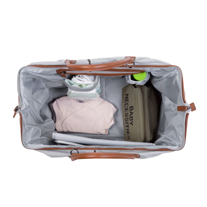 Open grijze Mommy Bag verzorgingstas van bovenaf, gevuld met luiers, babykleding en een opbergtasje.