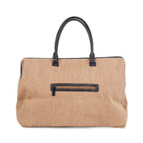 Achterkant van de beige Mommy Bag verzorgingstas met raffialook, zwart ritsvak en zwarte handvatten.