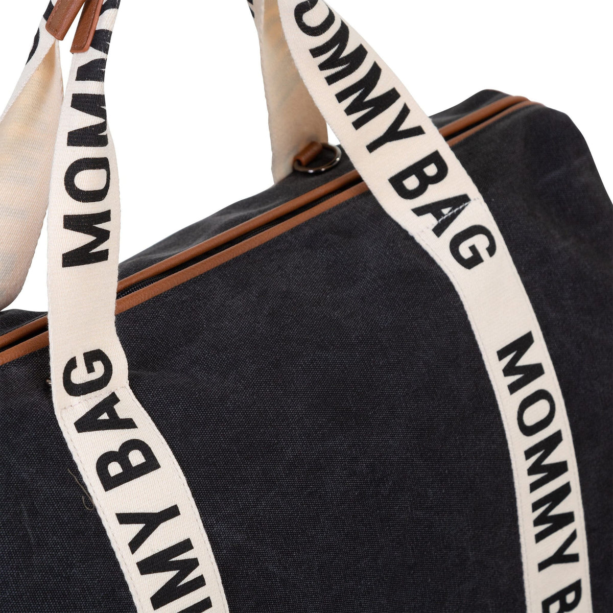 Close-up van de zwarte Mommy Bag verzorgingstas met brede crèmekleurige banden en bruine details.