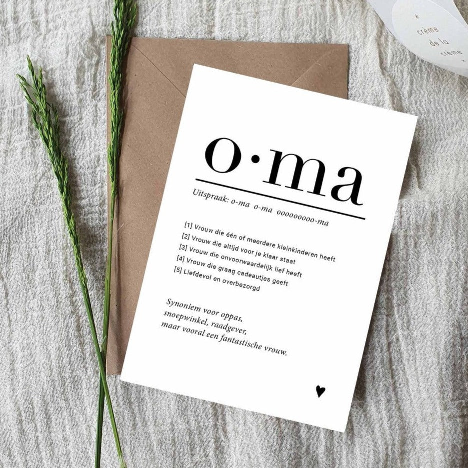 Witte ansichtkaart Oma met zwarte tekst en een hartje, op een bruine envelop naast groene takjes.