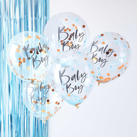 Vijf transparante Baby Boy-ballonnen met blauwe en goudkleurige confetti voor een blauw franjegordijn.