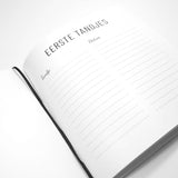 Open babyboek met invulpagina voor de eerste tandjes, kolommen voor tandje en datum en een zwart leeslint.