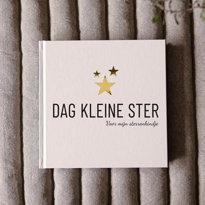 Invulboek Dag Kleine Ster op grijze stof, met lichte kaft, drie gouden sterren en de tekst ‘Voor mijn sterrenkindje’.