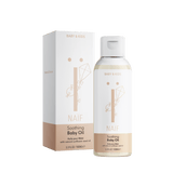 Naïf Verzachtende Babyolie in een transparante fles van 100 ml met witte dop, naast de verpakking.