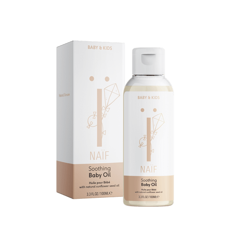 Naïf Verzachtende Babyolie in een transparante fles van 100 ml met witte dop, naast de verpakking.
