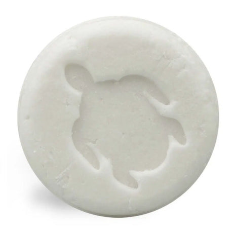 Witte, ronde Shampoo Bar Baby met een schildpadmotief, tegen een witte achtergrond.